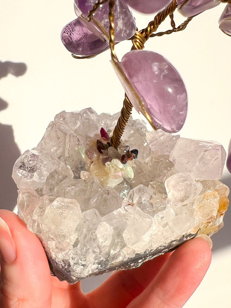 Crystal with purple stones on a white background