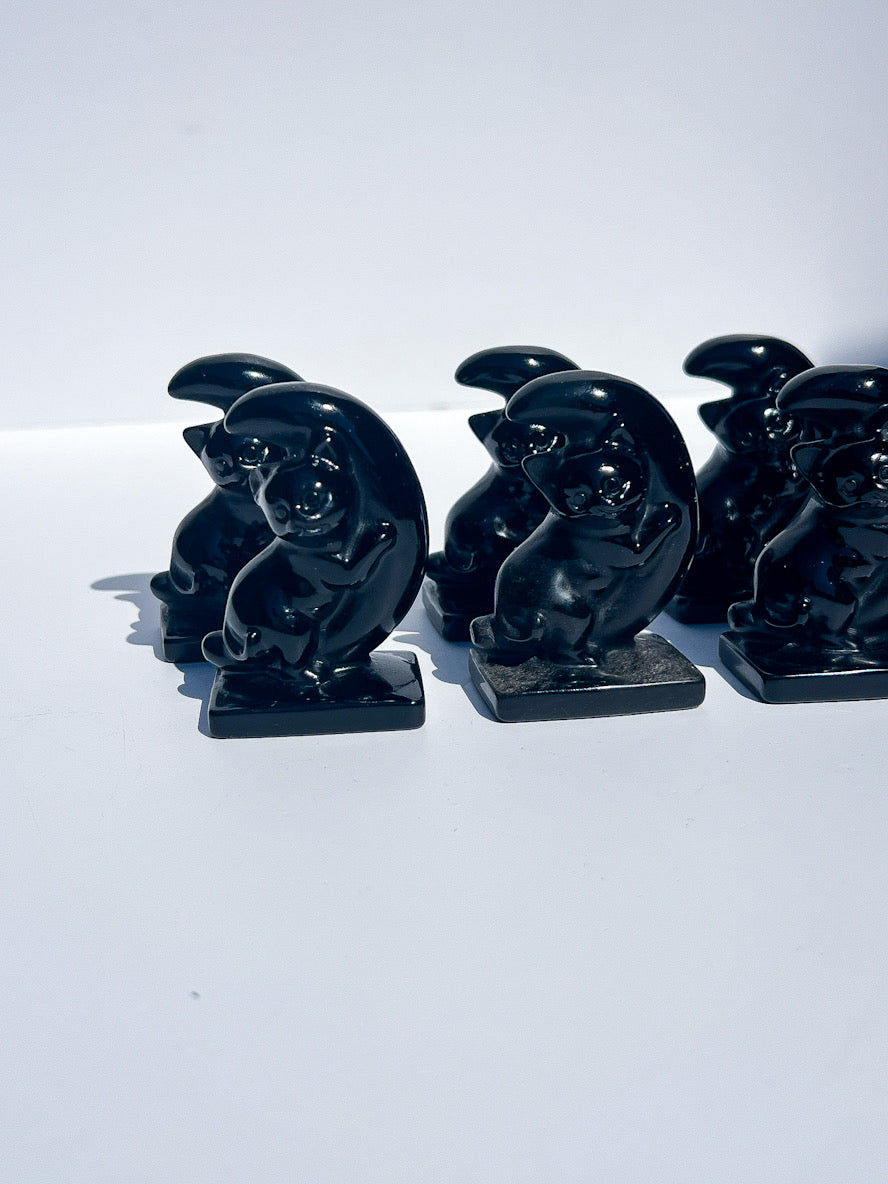 Set of black cat figurines on a white background
