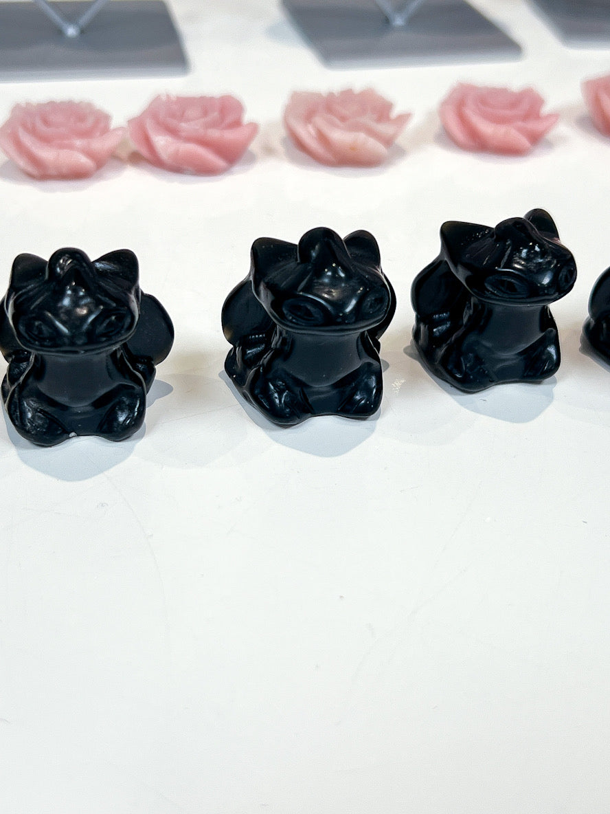 Black dragons on a white surface with pink roses in the background.