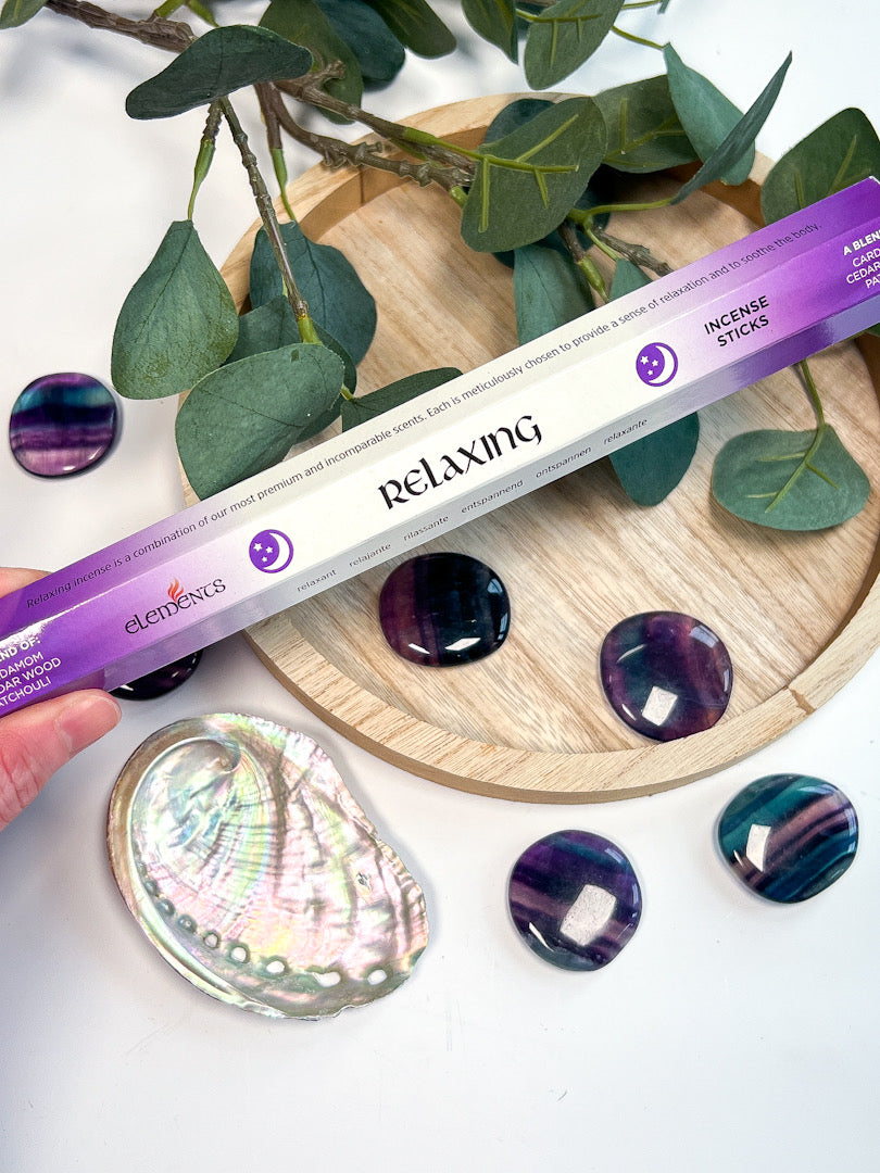 Elements Relaxing Incense Sticks packaging with decorative stones and leaves on a wooden board