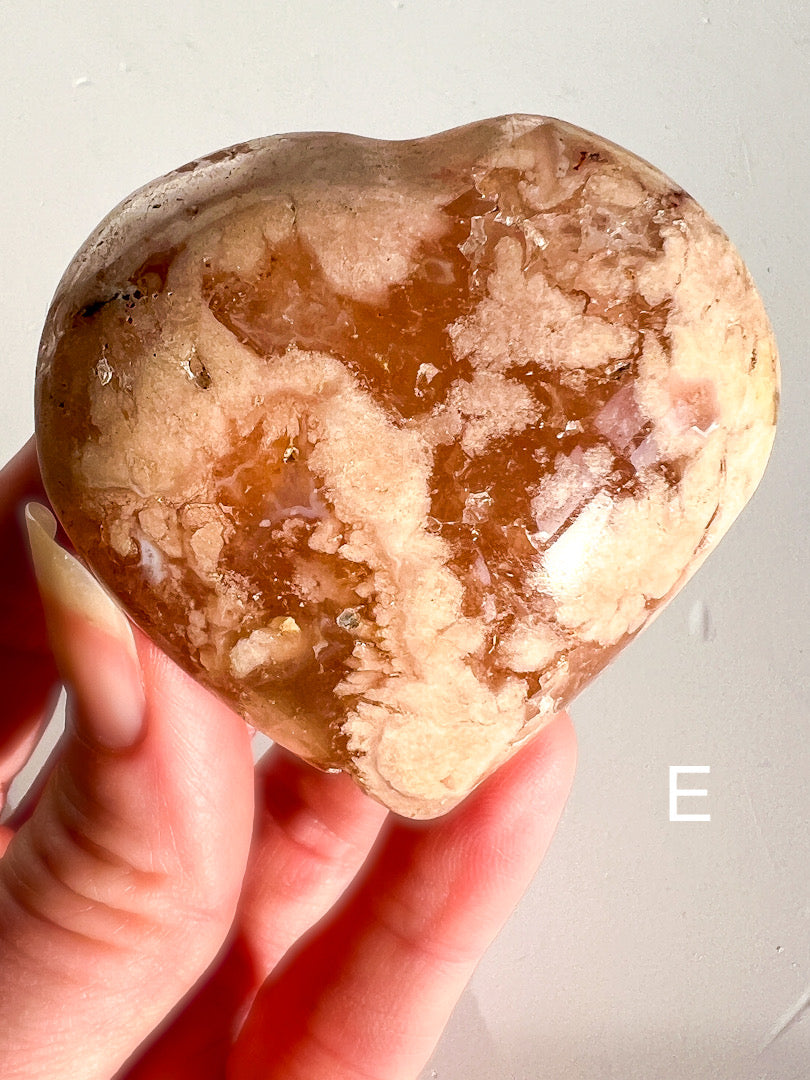 Hand holding a marbled stone against a plain background