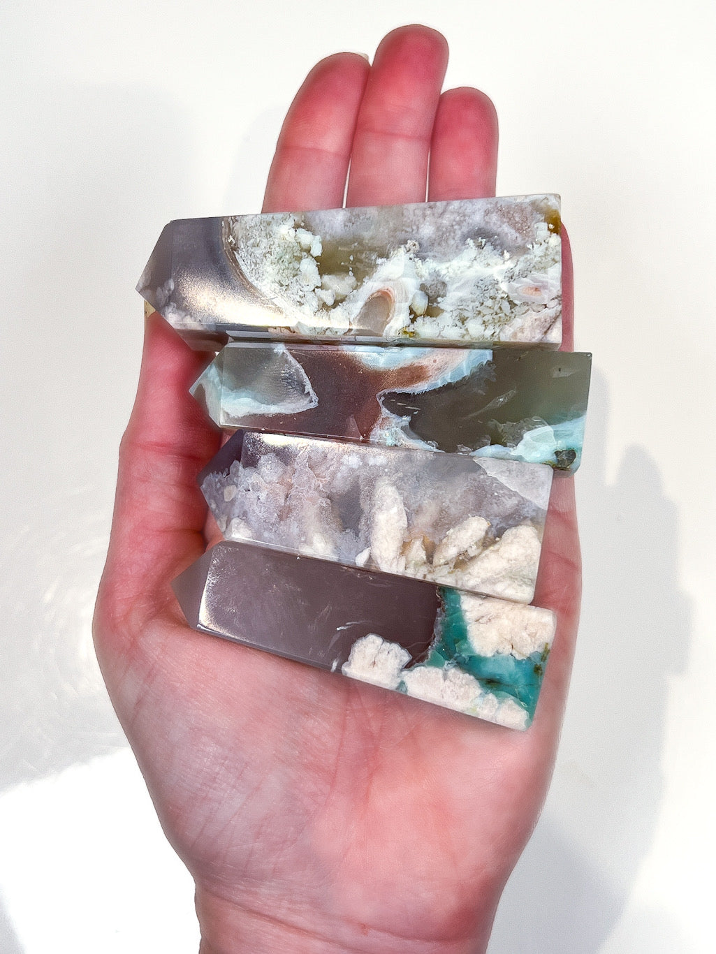 Hand holding a set of multicolored crystal blocks with a white background