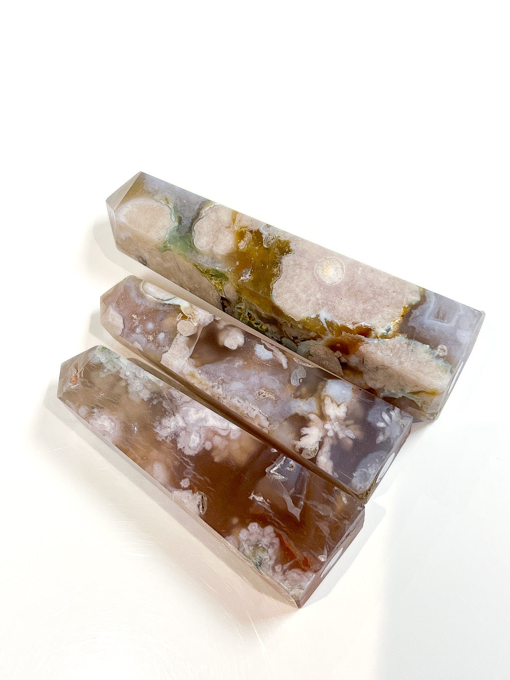 Three crystal-like bars with a natural, earthy color palette on a white background