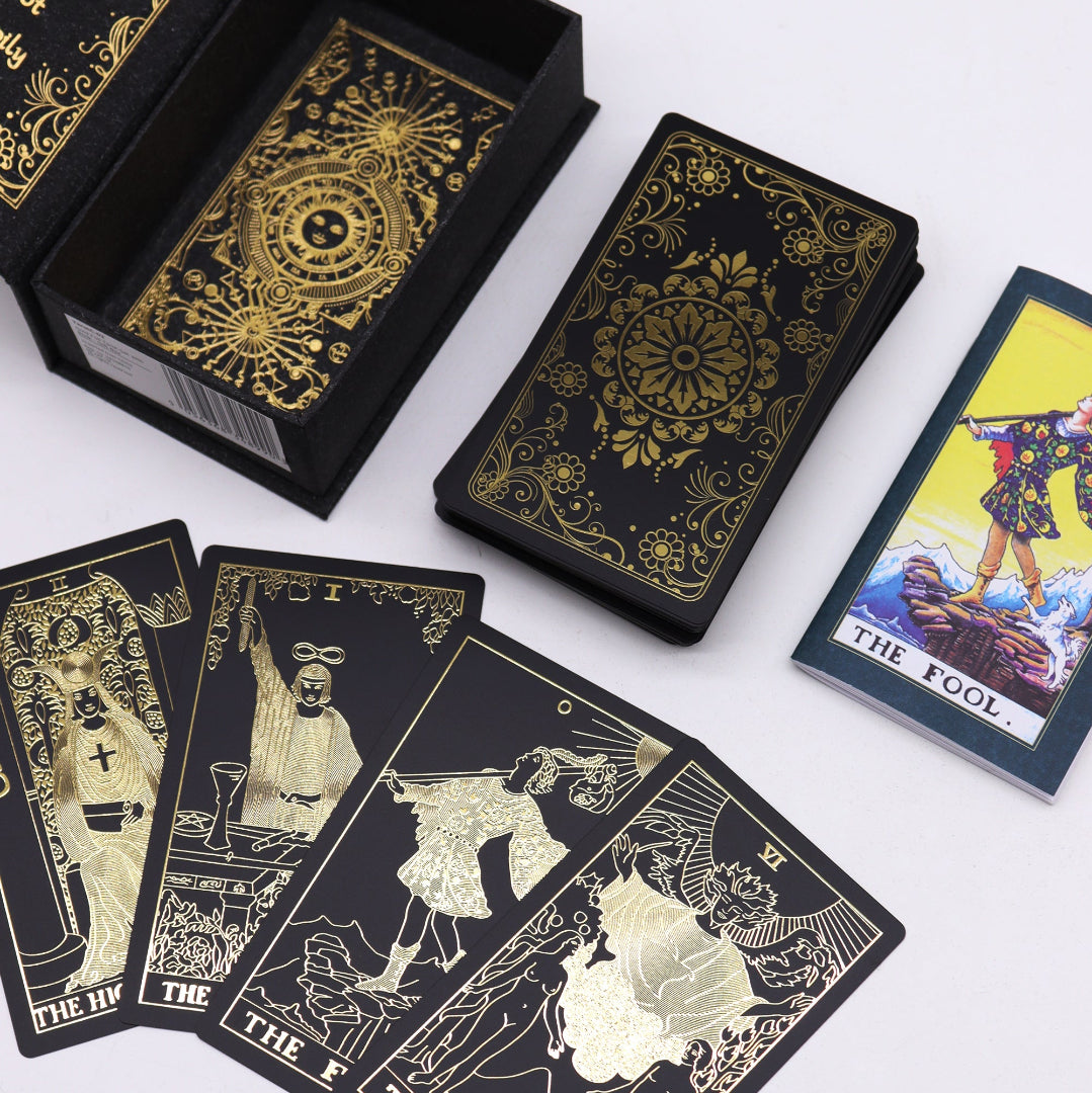 Black tarot cards with gold designs and illustrations on a white background
