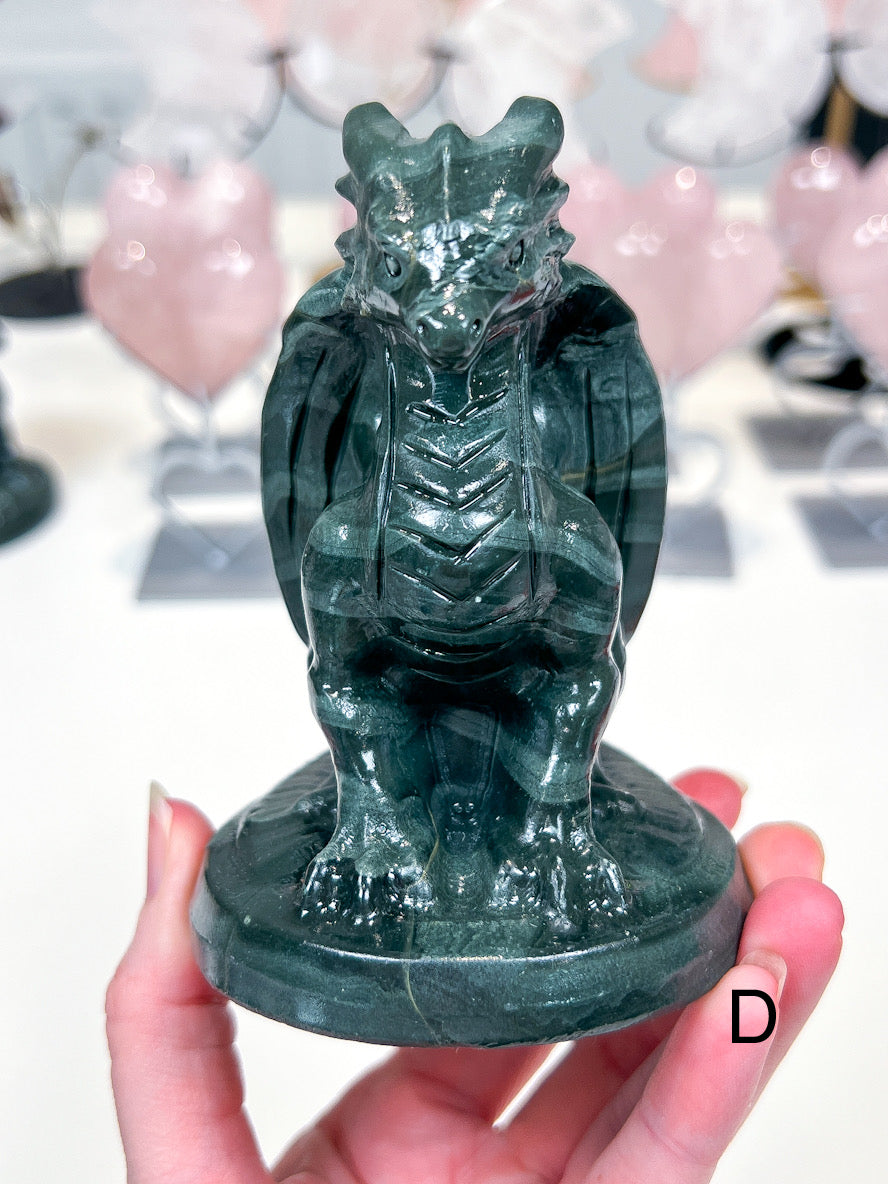 Green crystal dragon statue held in a hand with a blurred background