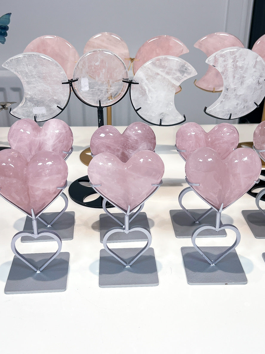 Heart-shaped pink crystal objects on stands with a blurred background