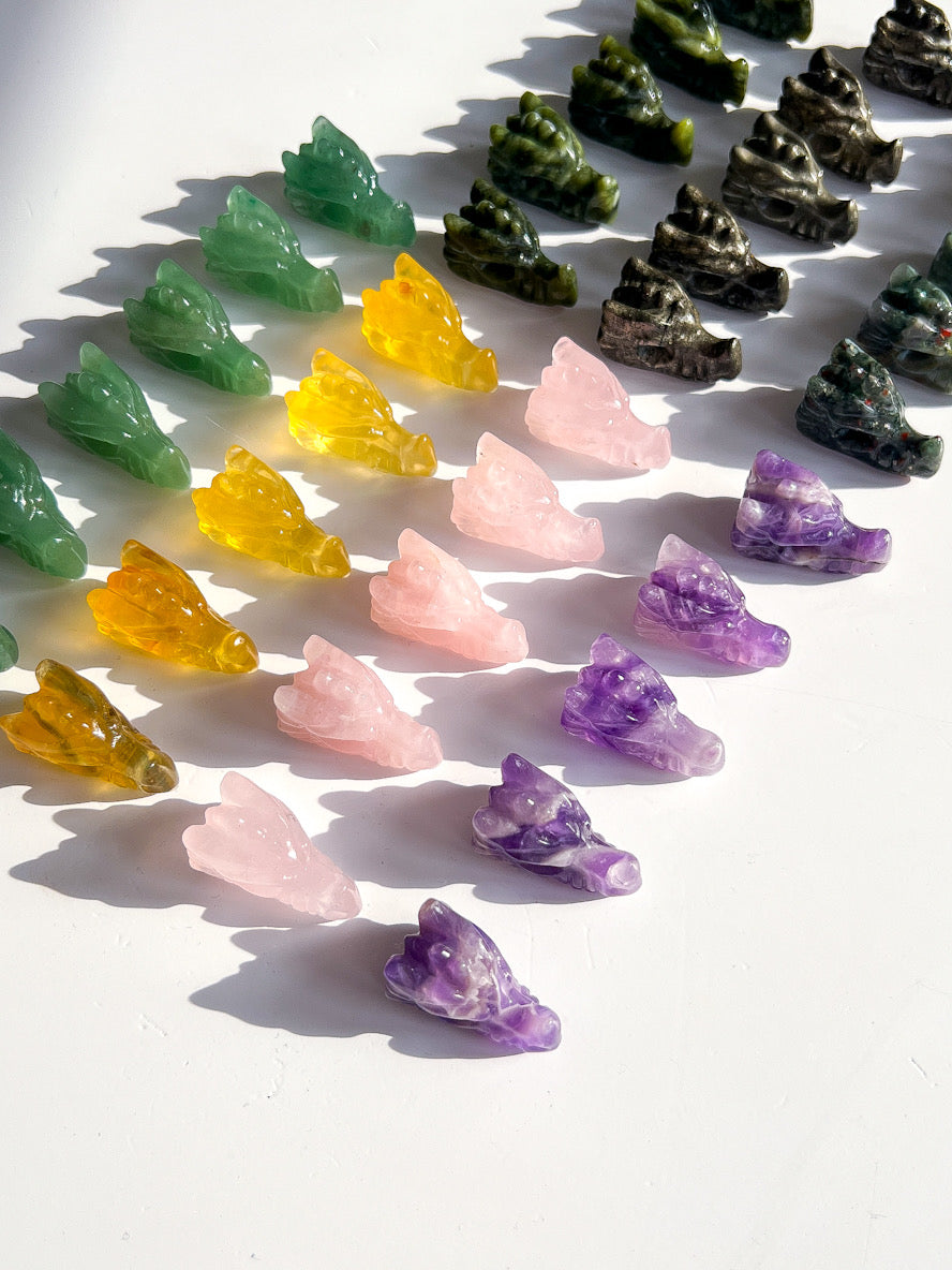 Colorful crystal figurines arranged in rows on a white surface