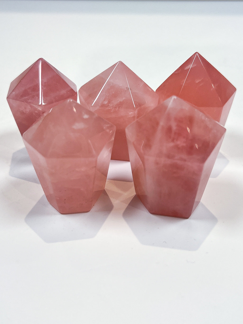 Set of pink crystal-like objects on a white background