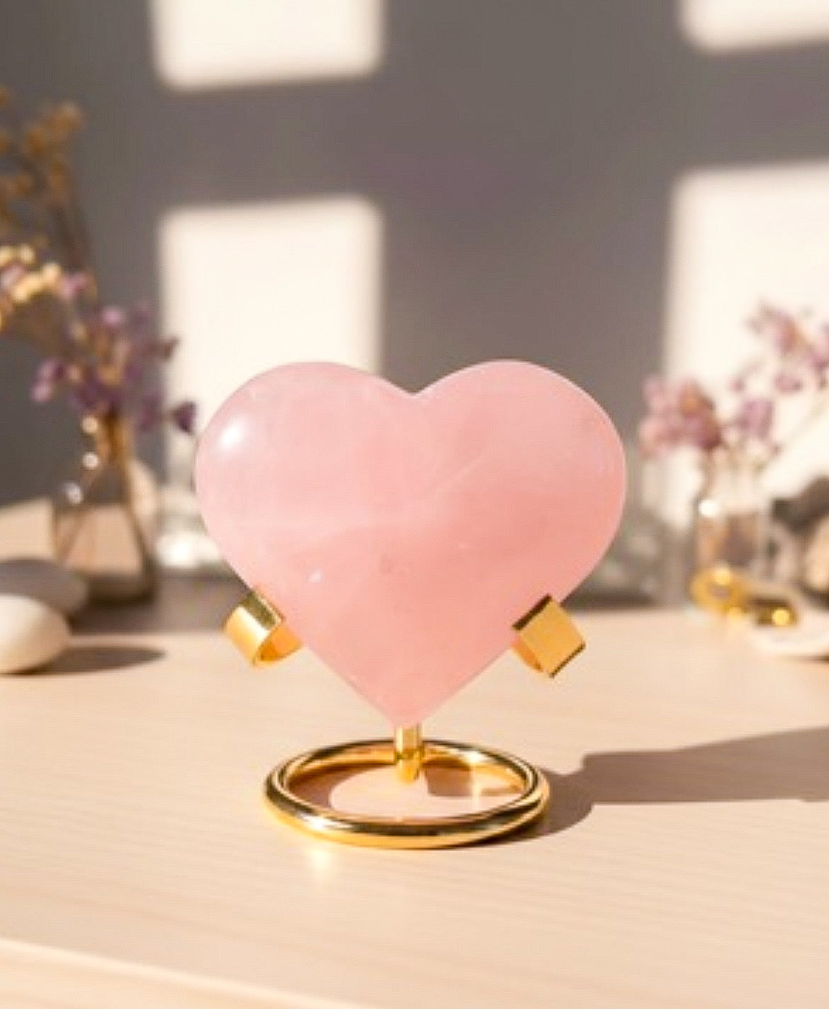 Pink heart-shaped object on a gold stand with a blurred background