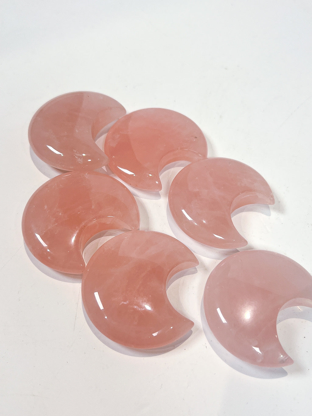 Rose Quartz moon carvings on white background
