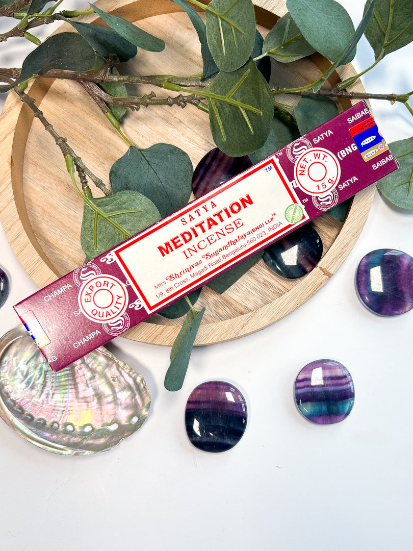 Satya Meditation incense with greenery and crystals in the background.