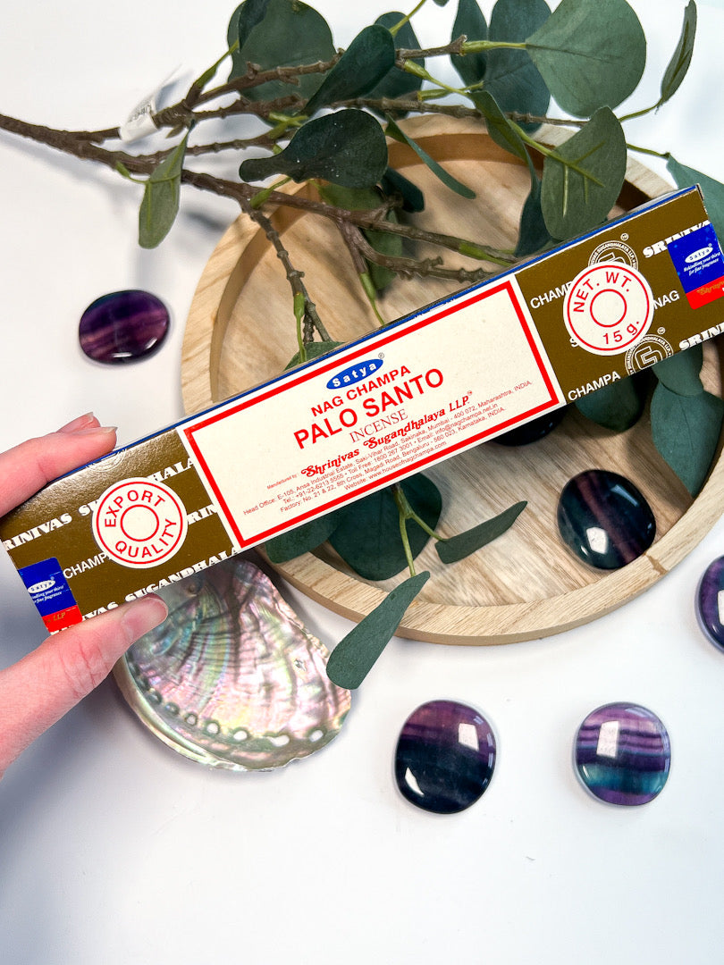 Box of Palo Santo incense held by a hand with a natural background