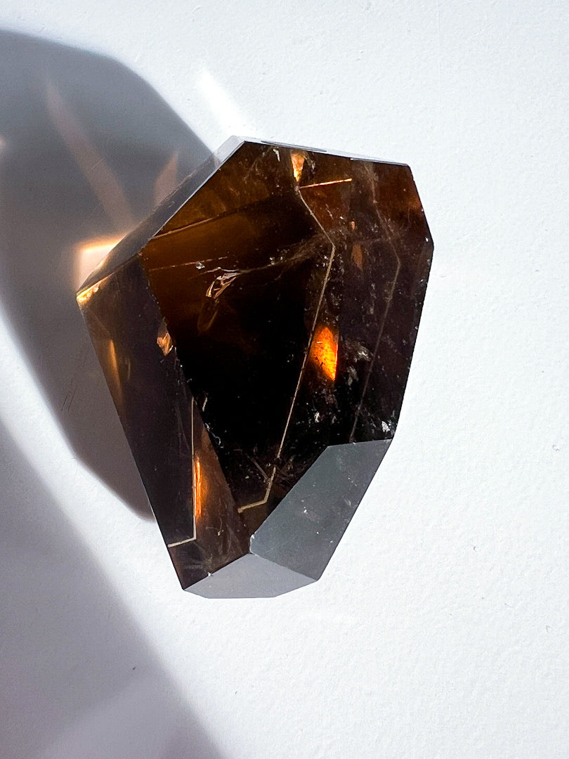 Faceted brown gemstone on a white background