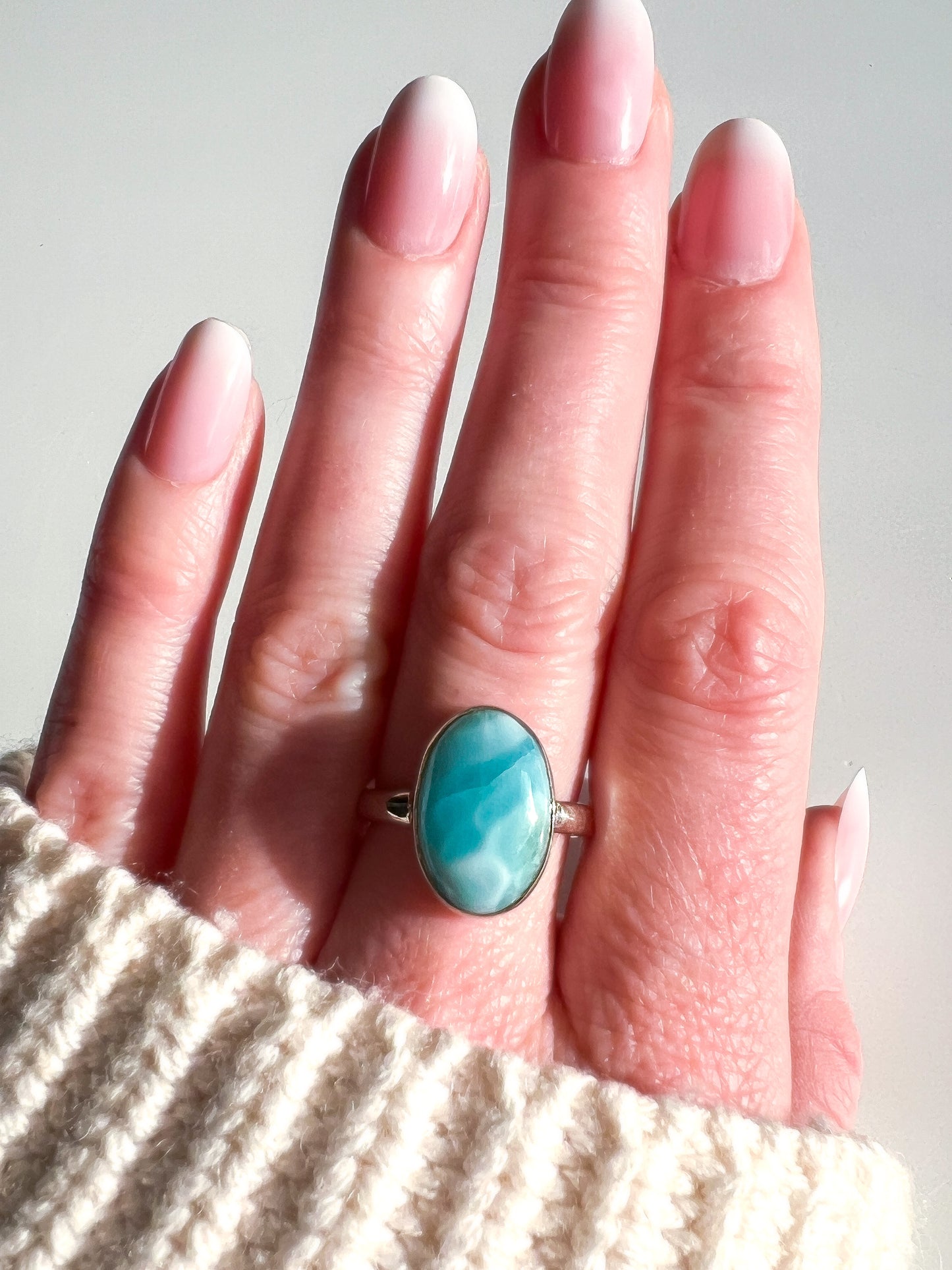 Turquoise ring on a hand with a neutral background